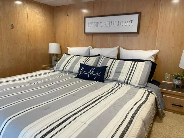 Slide: The Image of Bedroom in 2016 Sunstar 16x58 houseboat with striped bedding and decorative pillows. - 33