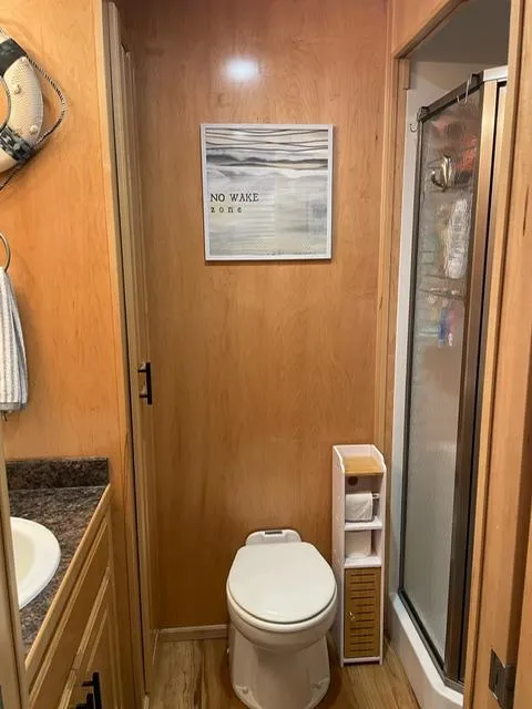 Slide: The Image of Compact bathroom in a 2016 Sunstar 16x58 houseboat with wood paneling and modern amenities. - 41