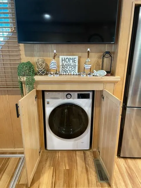 Slide: The Image of Compact laundry area in a Sunstar 16x58 houseboat, featuring a modern washer and nautical decor. - 43