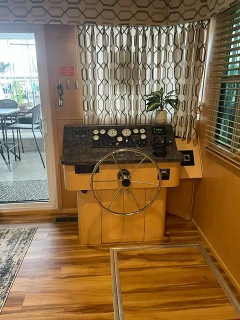 Slide: The Image of Helm of 2016 Sunstar 16x58 houseboat with wooden flooring and patterned curtains. - 45