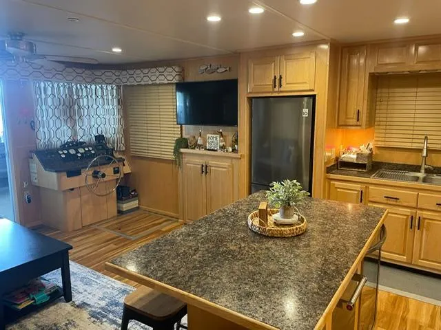 Slide: The Image of Modern kitchen interior in a 2016 Sunstar 16x58 houseboat with wood cabinetry and granite countertops. - 5
