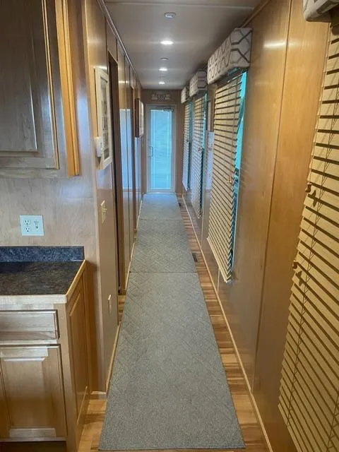 Slide: The Image of Hallway inside 2016 Sunstar 16x58 houseboat with wooden paneling and carpet runner. - 9