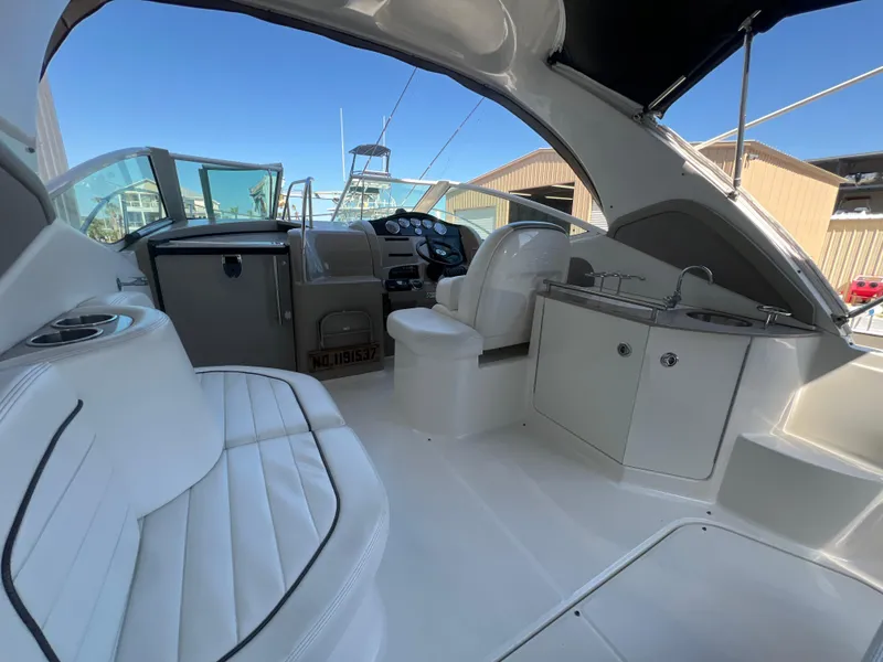 Slide: The Image of 2006 Sea Ray 290 Sundancer interior with white seating and helm, showcasing luxury design. - 10