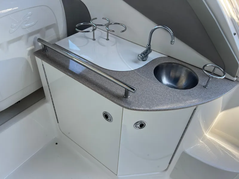 Slide: The Image of 2006 Sea Ray 290 Sundancer boat kitchenette with sink and cup holders. - 11