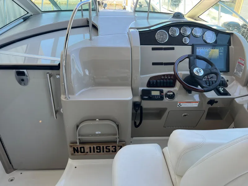 Slide: The Image of 2006 Sea Ray 290 Sundancer helm with steering wheel, gauges, and navigation controls. - 16