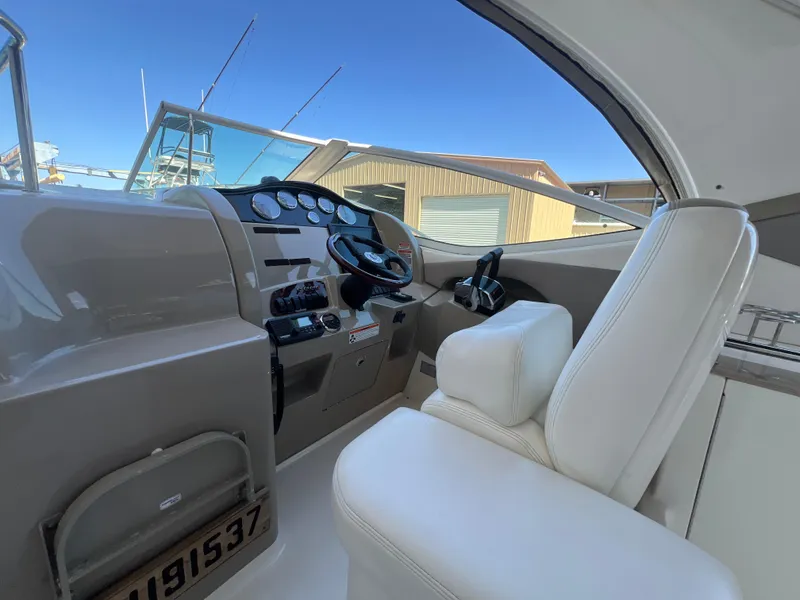 Slide: The Image of 2006 Sea Ray 290 Sundancer helm with white seating and control panel. - 17