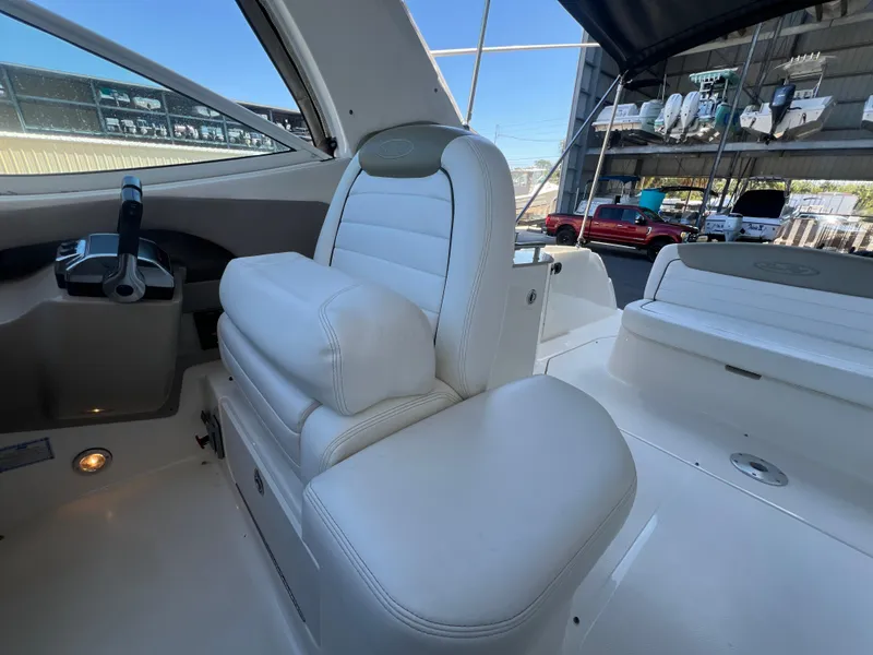 Slide: The Image of 2006 Sea Ray 290 Sundancer interior with white seating and helm controls. - 19