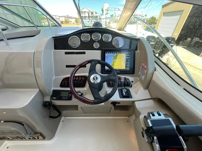 Slide: The Image of 2006 Sea Ray 290 Sundancer helm with steering wheel, gauges, and navigation display. - 21