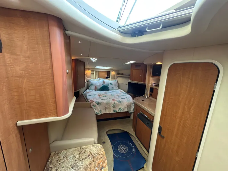 Slide: The Image of Interior of 2006 Sea Ray 290 Sundancer, featuring cozy cabin with bed and wooden finishes. - 23