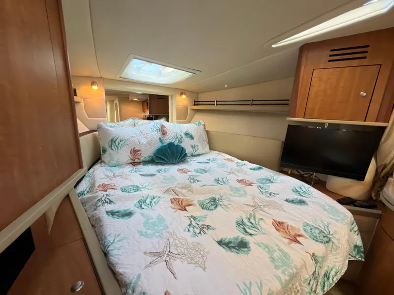 Slide: The Image of Cozy cabin interior of 2006 Sea Ray 290 Sundancer with bed and TV. - 26