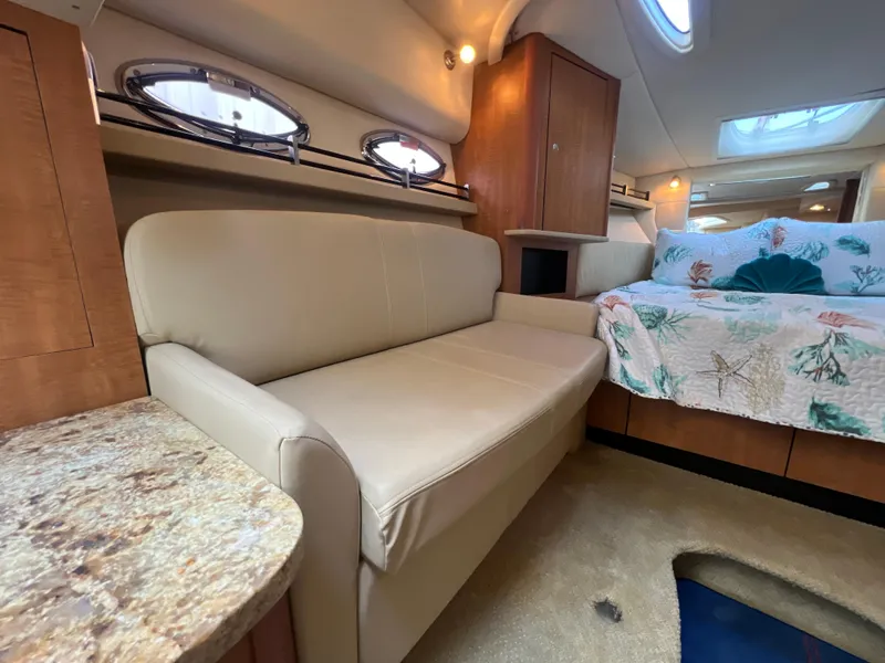 Slide: The Image of Interior of 2006 Sea Ray 290 Sundancer with beige sofa and cozy bed. - 27