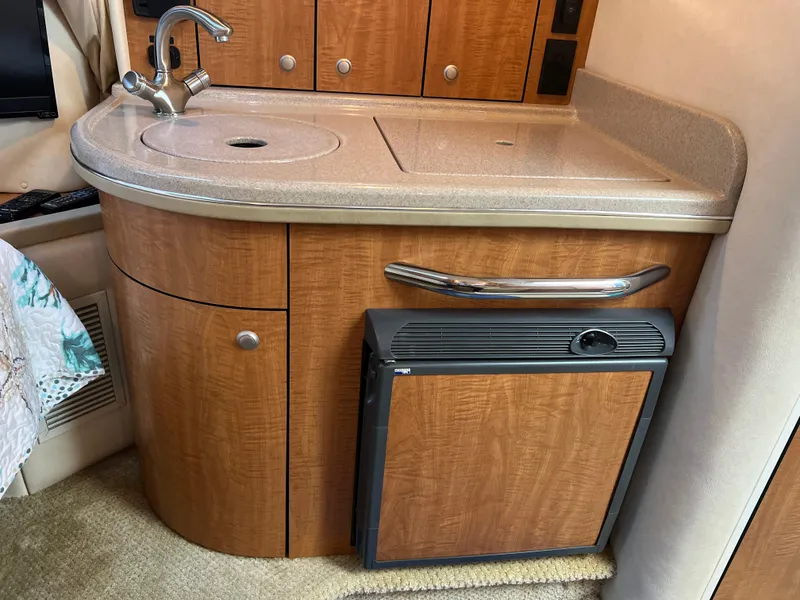 Slide: The Image of 2006 Sea Ray 290 Sundancer interior kitchenette with sink and mini fridge. - 31