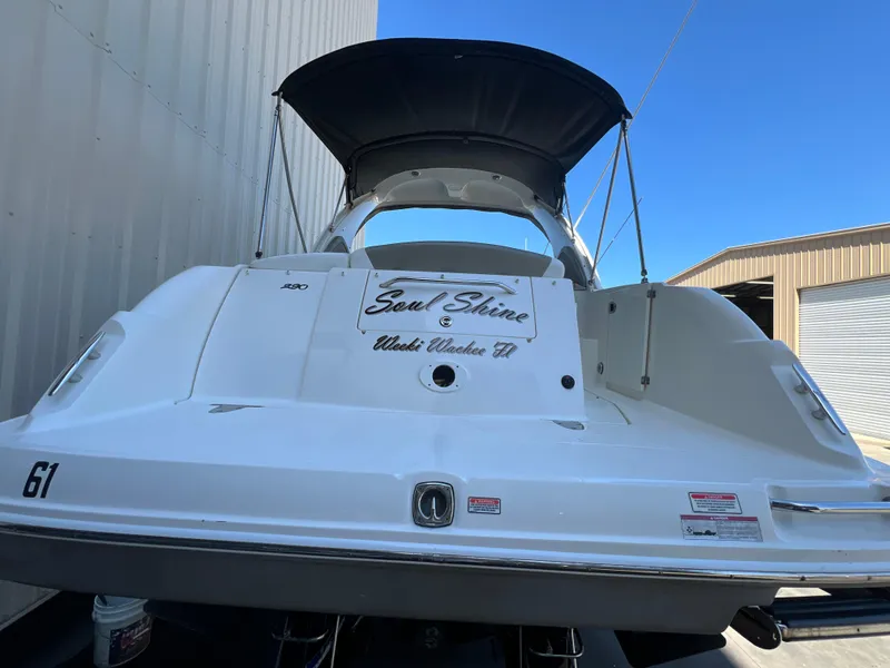 Slide: The Image of 2006 Sea Ray 290 Sundancer boat docked, featuring a sleek white exterior and black canopy. - 46