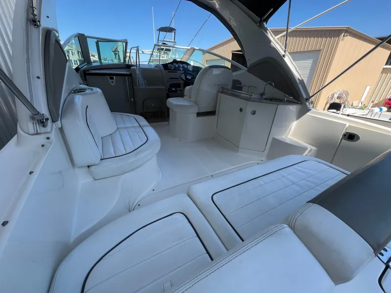 Slide: The Image of 2006 Sea Ray 290 Sundancer boat interior with white seating and helm. - 5