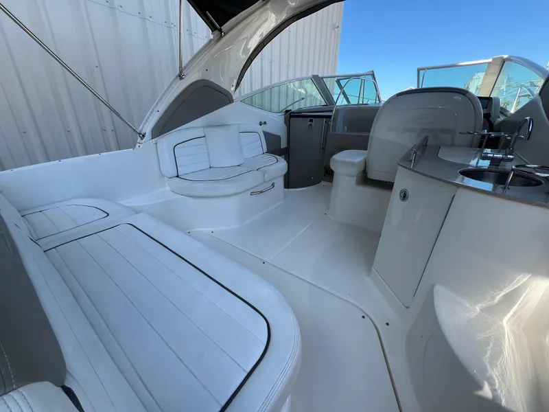 Slide: The Image of 2006 Sea Ray 290 Sundancer boat interior with white seating and helm station. - 7