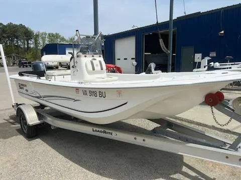 Slide: The Image of 2012 Carolina Skiff JVX18CC boat on trailer, parked near blue building. - 1