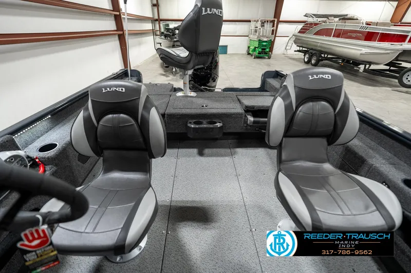 Slide: The Image of 2025 Lund 1675 Adventure SS boat interior with three gray seats in a showroom. - 12