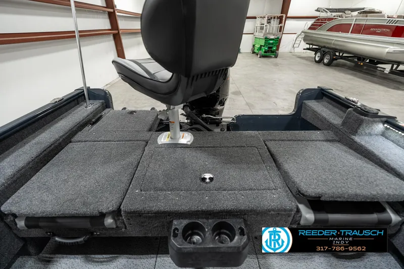 Slide: The Image of 2025 Lund 1675 Adventure SS boat interior with seating and storage compartments in a showroom. - 13