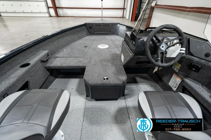 Slide: The Image of 2025 Lund 1675 Adventure SS boat interior with steering wheel and seating in a showroom. - 15