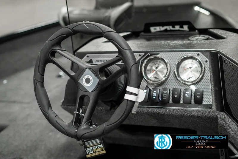 Slide: The Image of 2025 Lund 1675 Adventure SS dashboard with steering wheel and gauges, Reeder-Trausch Marine branding. - 26