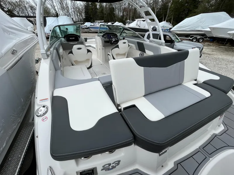Slide: The Image of 2023 Chaparral 23 SSIOB boat with sleek seating and modern design in a marina setting. - 10