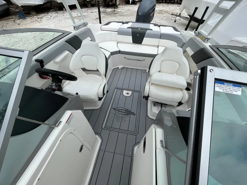 Slide: The Image of 2023 Chaparral 23 SSIOB boat interior with white seating and sleek design. - 13