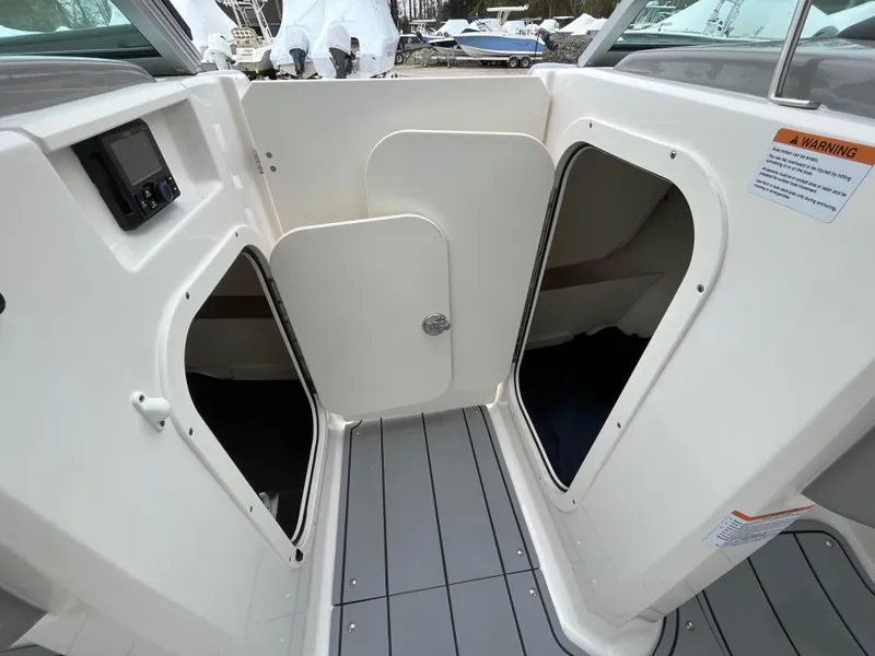 Slide: The Image of 2023 Chaparral 23 SSIOB boat interior with open storage compartments and sleek design. - 16