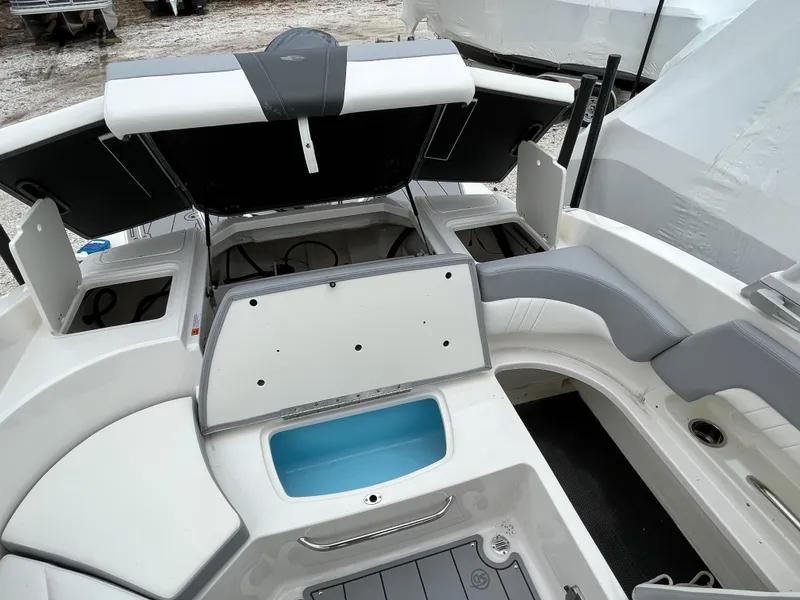 Slide: The Image of 2023 Chaparral 23 SSIOB boat interior with open storage compartments and seating. - 18