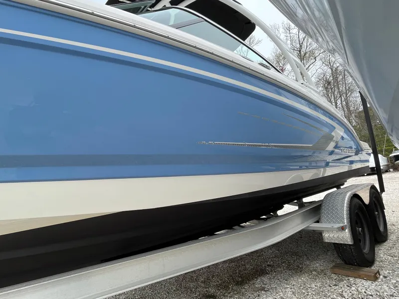 Slide: The Image of 2023 Chaparral 23 SSIOB boat in blue on a trailer, side view. - 4