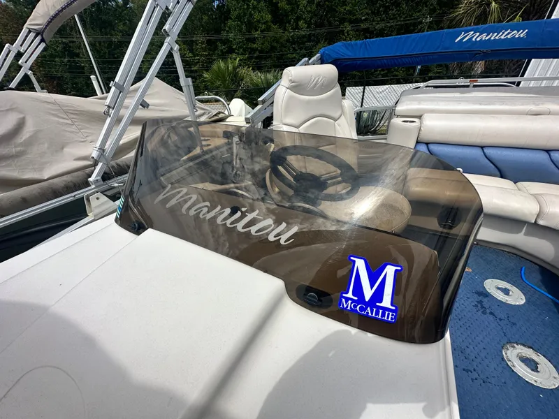 Slide: The Image of 2008 Manitou 24 Legacy boat dashboard with steering wheel and windshield. - 3