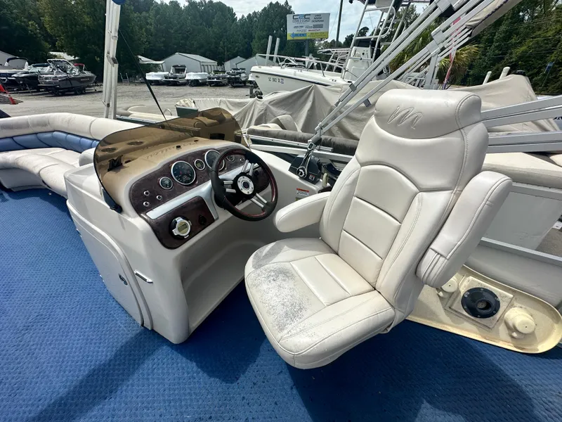 Slide: The Image of 2008 Manitou 24 Legacy boat interior with captain's chair and control panel. - 6