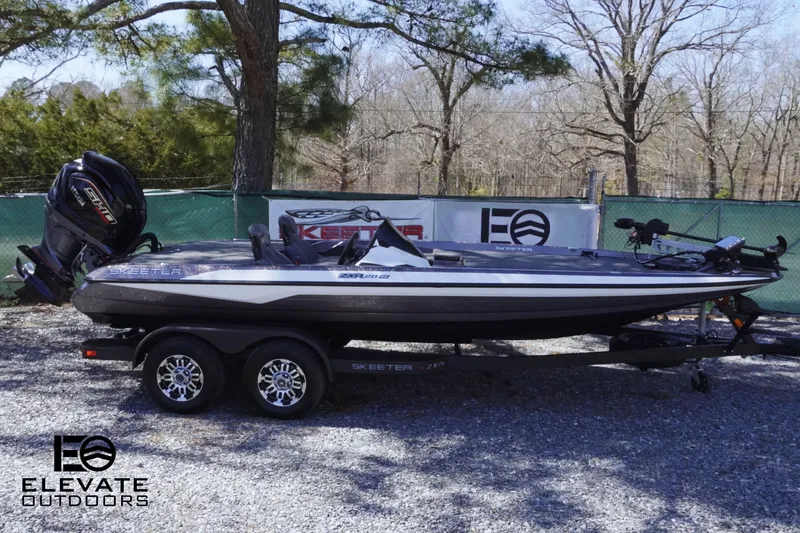 Slide: The Image of 2025 Skeeter ZXR 20 SE boat on trailer, parked outdoors with trees in background. - 3
