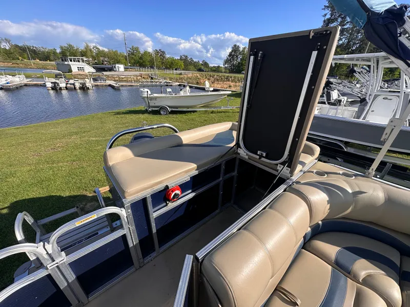 Slide: The Image of 2011 Avalon Windjammer 24' pontoon boat with beige seating, docked near a marina. - 3