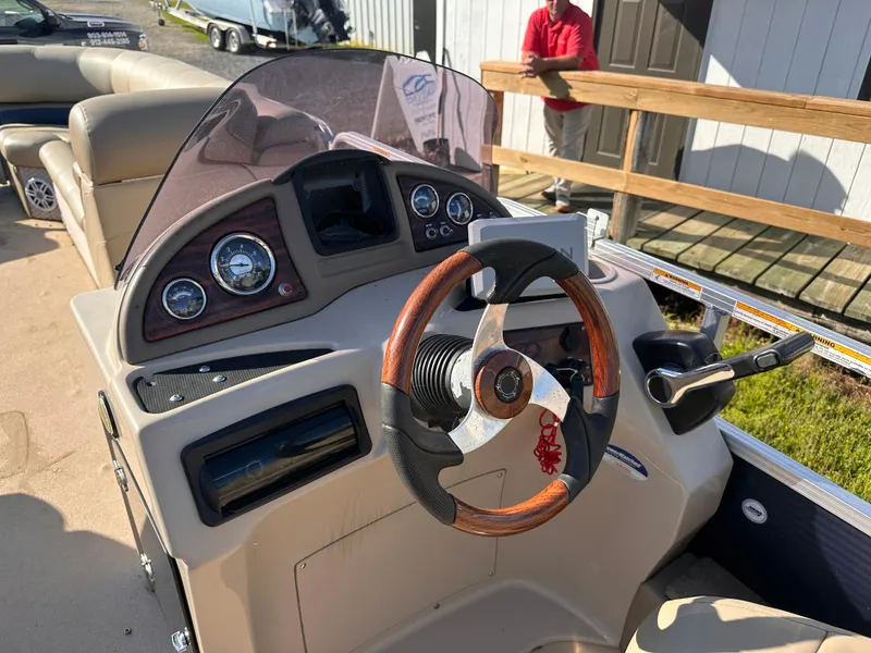 Slide: The Image of 2011 Avalon Windjammer 24' boat dashboard with steering wheel and control panel. - 4