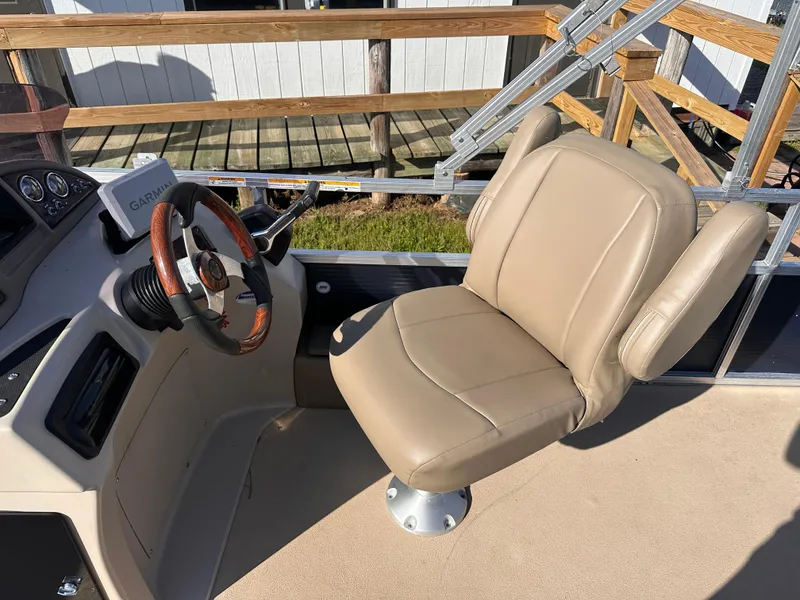 Slide: The Image of Captain's chair and helm of 2011 Avalon Windjammer 24' boat with wooden steering wheel. - 6