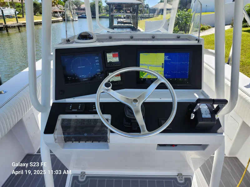 Slide: The Image of Center console of a 2001 Jupiter 31 Open boat with navigation screens and steering wheel. - 10