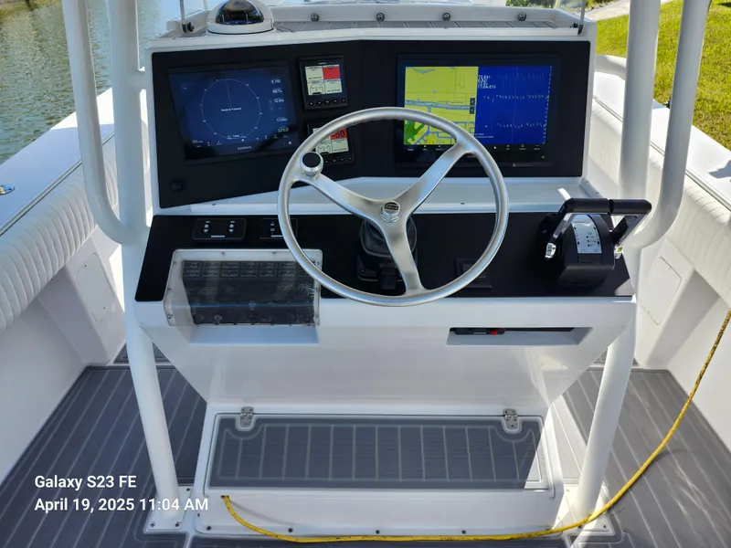 Slide: The Image of Center console of 2001 Jupiter 31 Open boat with navigation screens and steering wheel. - 11