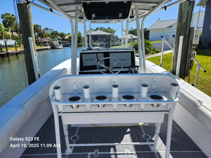 Slide: The Image of 2001 Jupiter 31 Open Center Console boat docked by a canal, featuring rod holders and steering console. - 25