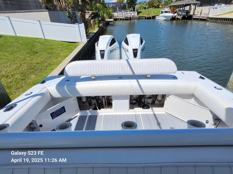 Slide: The Image of 2001 Jupiter 31 Open Center Console boat with dual Honda engines docked by a canal. - 31