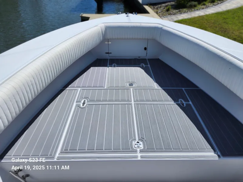 Slide: The Image of 2001 Jupiter 31 Open Center Console boat deck with cushioned seating, docked by the water. - 35