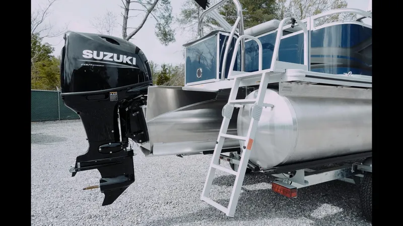 Slide: The Image of 2025 Tahoe Pontoon Sport 85 Cruise with Suzuki outboard motor and ladder on gravel. - 10