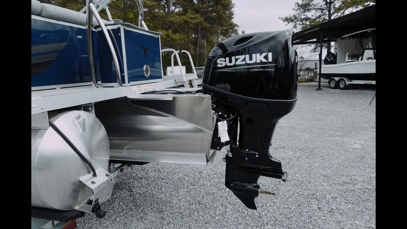 Slide: The Image of 2025 Tahoe Pontoon Sport 85 Cruise with Suzuki outboard motor, parked on gravel. - 11
