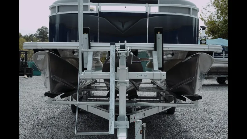 Slide: The Image of 2025 Tahoe Pontoon Sport 85 Cruise on trailer, rear view, parked on gravel. - 26