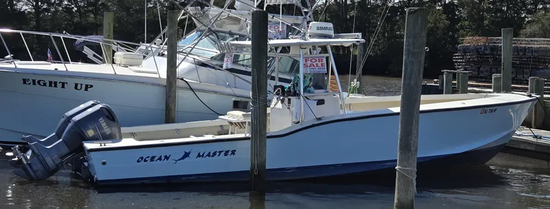 Slide: The Image of 1988 Ocean Master 31 Center Console boat docked, with "For Sale" sign visible. - 2