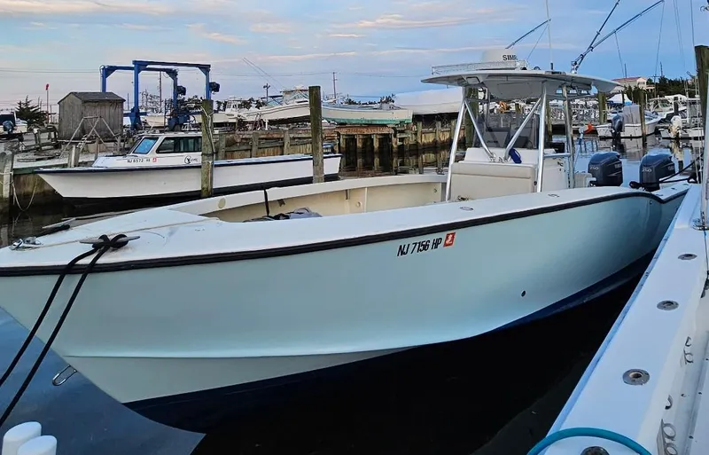 Slide: The Image of 1988 Ocean Master 31 Center Console boat docked at a marina, featuring twin engines. - 3
