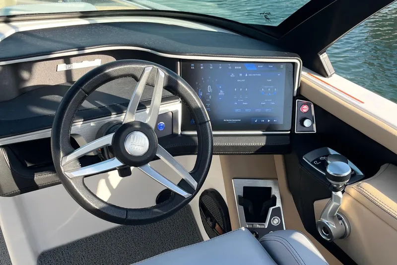Slide: The Image of 2025 MasterCraft XT24 boat dashboard with modern steering wheel and touchscreen controls. - 1