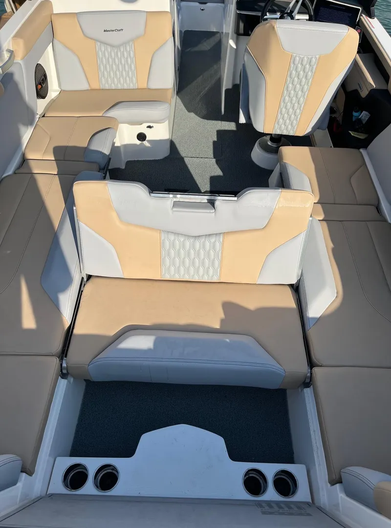 Slide: The Image of 2025 MasterCraft XT24 boat interior with beige and white seating, featuring modern design and ample space. - 7