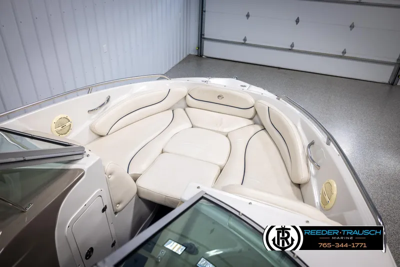Slide: The Image of 2006 Crownline 230 LS boat interior with cream leather seating in a garage. - 19