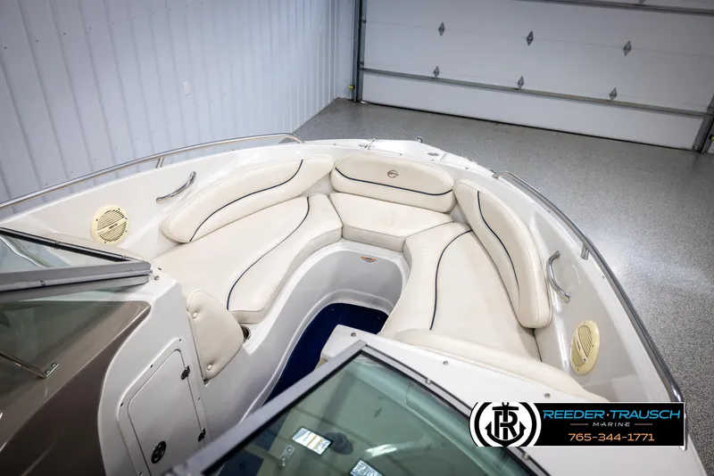 Slide: The Image of 2006 Crownline 230 LS boat interior with white cushioned seating in a garage. - 20