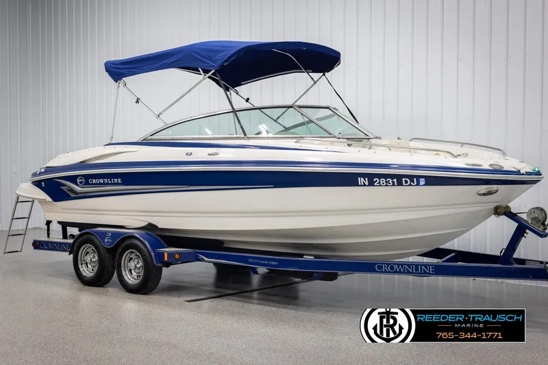 Slide: The Image of 2006 Crownline 230 LS boat with blue canopy on trailer in showroom. - 3